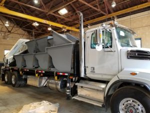 JT Fabrication crane truck and flatbed truck body loaded with self dump hoppers